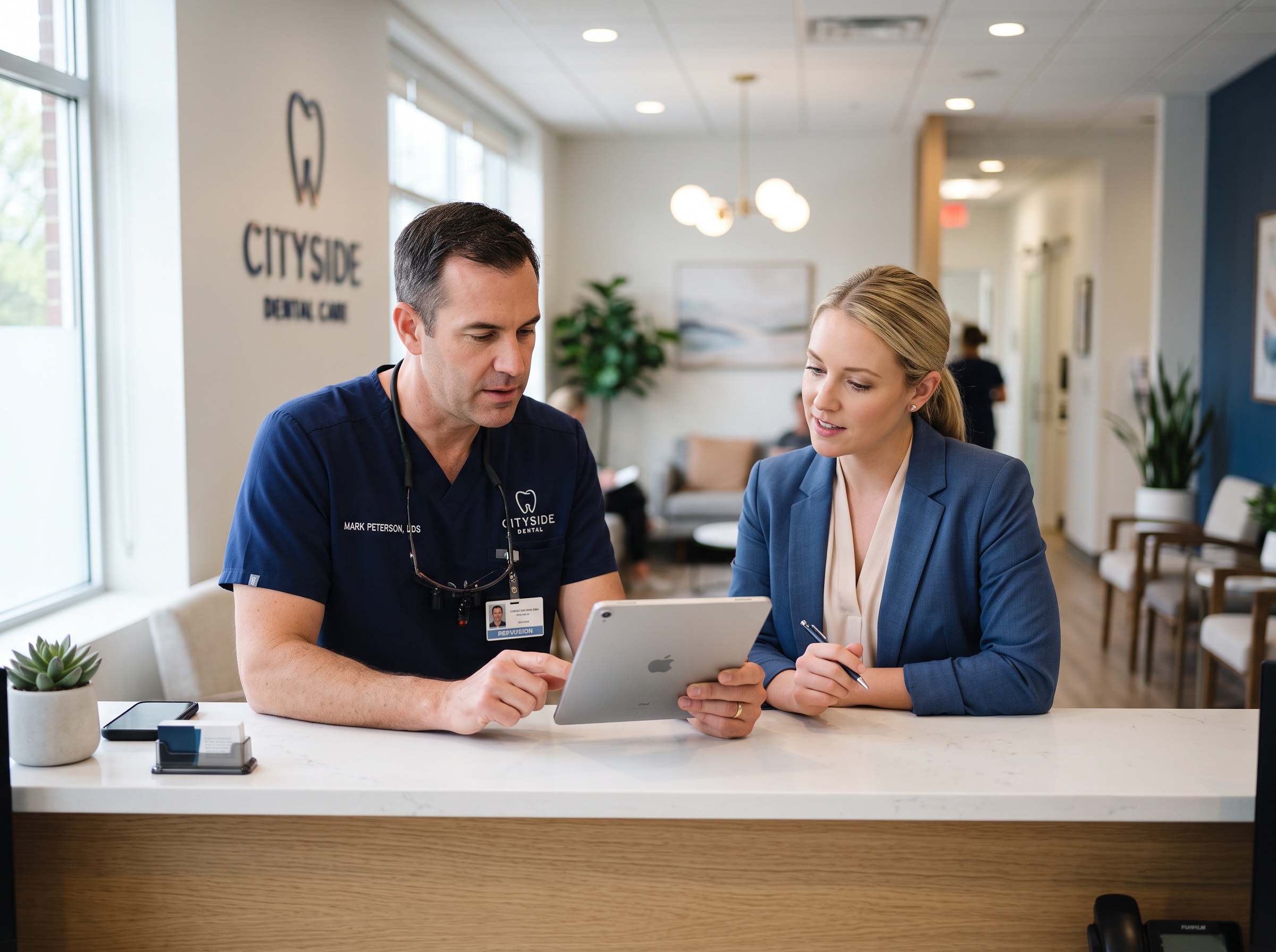 A dentist and practice manager reviewing a cybersecurity compliance checklist on a tablet